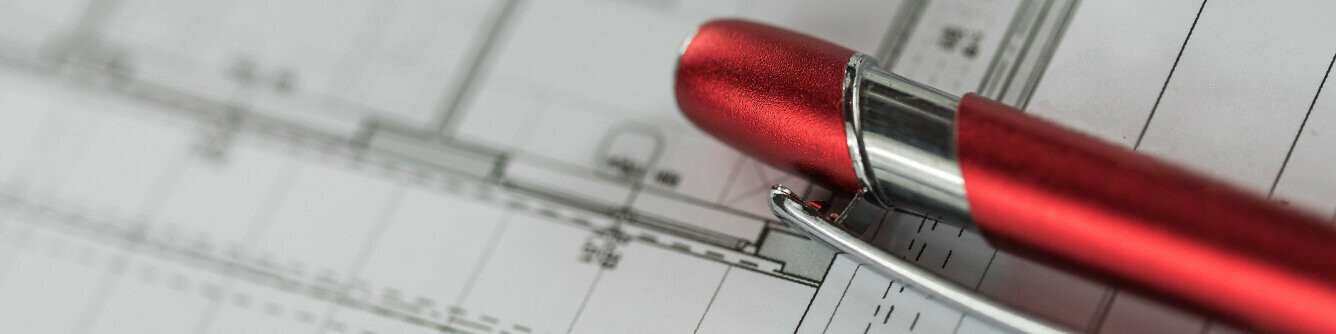 Červené kuličkové pero PREFA leží na plánu