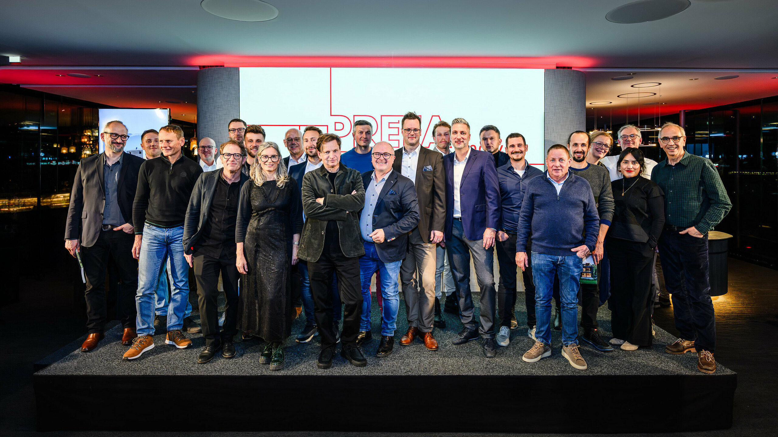 Společná fotografie architektů, projektantů a dodavatelů na pódiu prezentace PREFARENZEN 2026 v k47.wien – silného symbolu komunity, kreativity a progresivní architektury. Před osvětleným logem PREFARENZEN stojí designéři stojící za působivými projekty s hliníkem PREFA. Scéna odráží hrdost, inovaci a spolupráci. Produkty PREFA nabízejí trvanlivá, povětrnostně odolná řešení s estetickým vzhledem – ideální pro moderní architektonické koncepty. Inspirativní večer plný výměny názorů, vizí a silných partnerství.