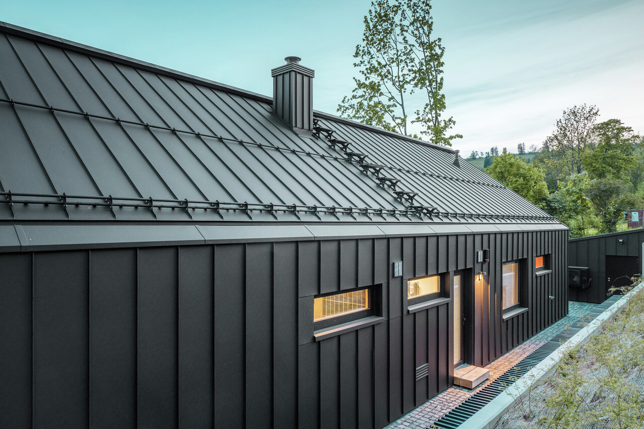 Střecha a fasáda z PREFALZ v barvě P.10 černé. Střecha má také protisněhové prvky PREFA.