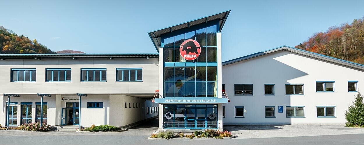 Firemní budova PREFA s bílou fasádou a modrými okny