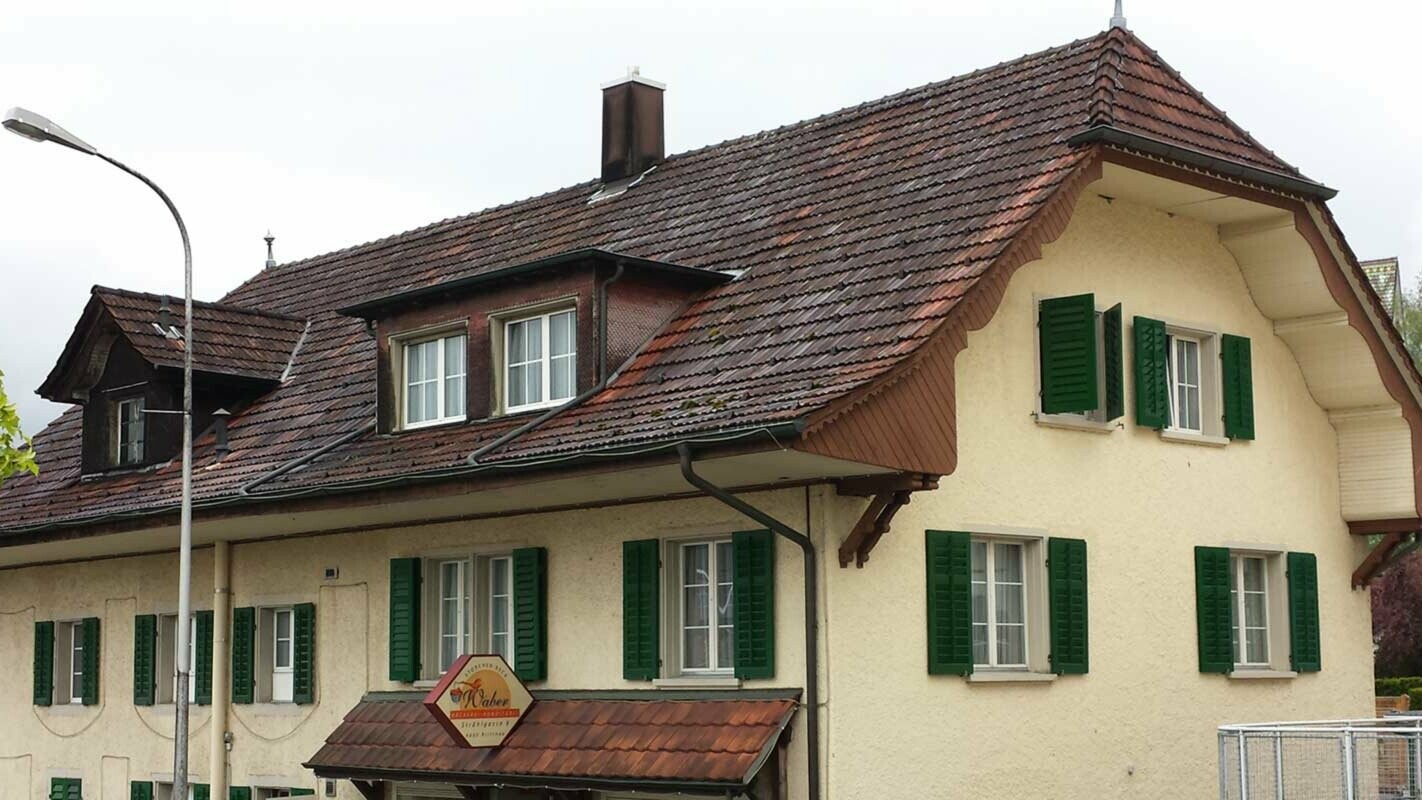 Polovalbová střecha před sanací za použití PREFA falcovaných střešních tašek v barvě antracitová P.10 