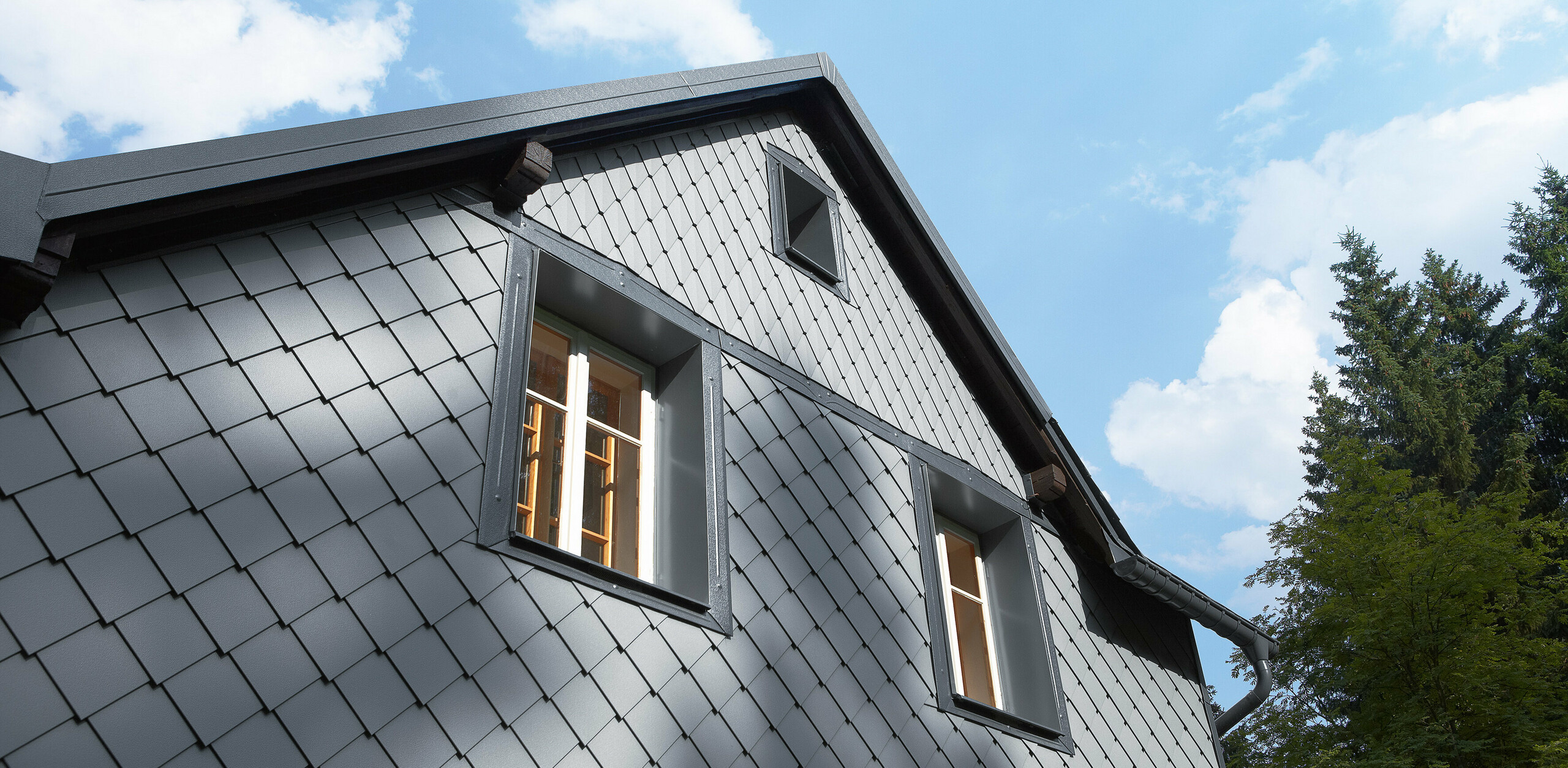 Návětrná strana obložená fasádními šablonami 20 × 20 a věžovkami na fasádě od firmy PREFA