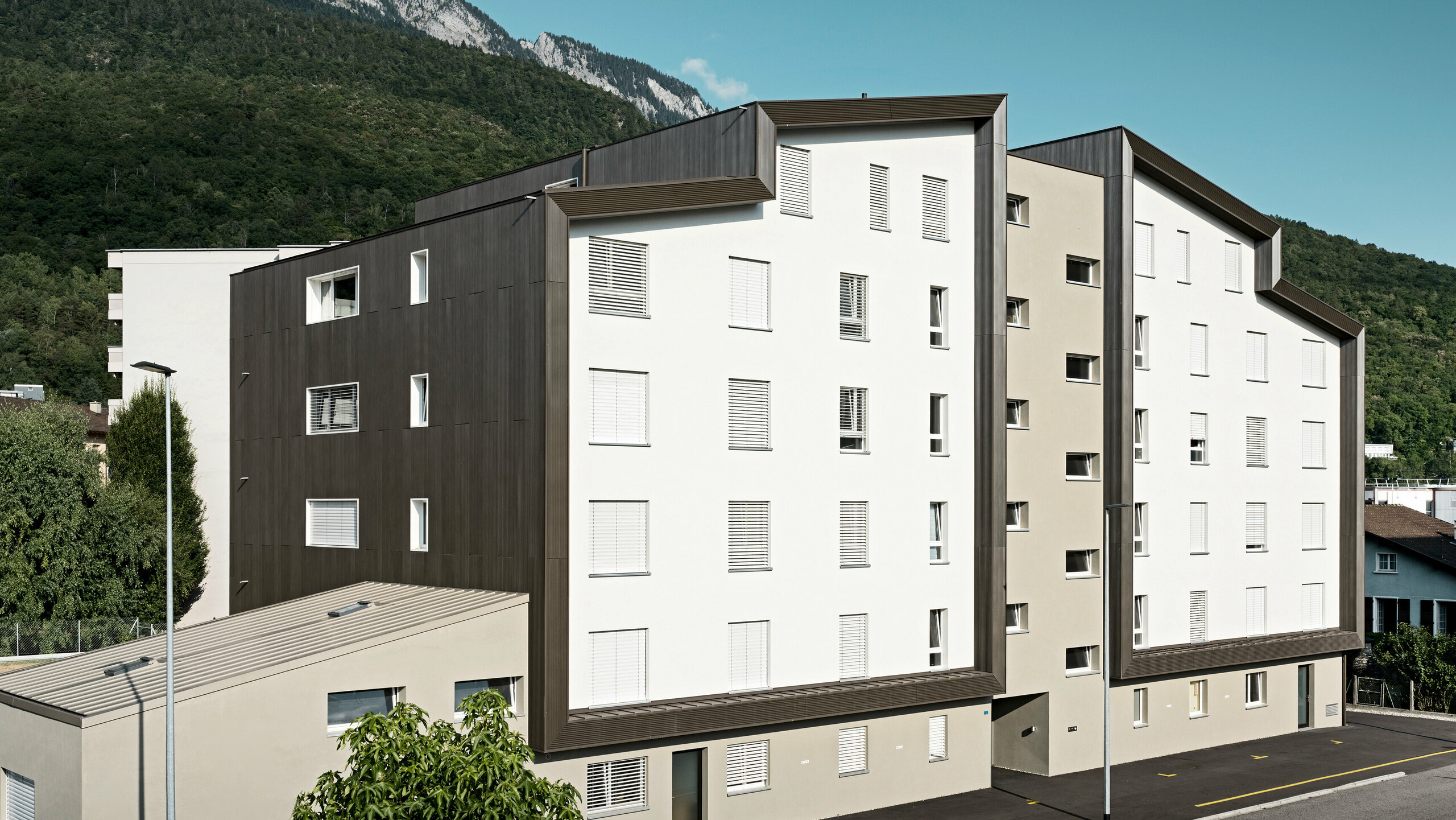 Obytný dům je laděn do bílo-bronzové barvy s hliníkovou fasádou PREFA