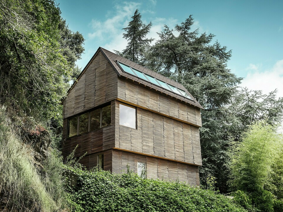 Dům v západní Francii s falcovanými šindeli PREFA v barvě P.10 oříškové na strmém kopci – moderní design s proutěnou fasádou a energeticky úspornou střechou.