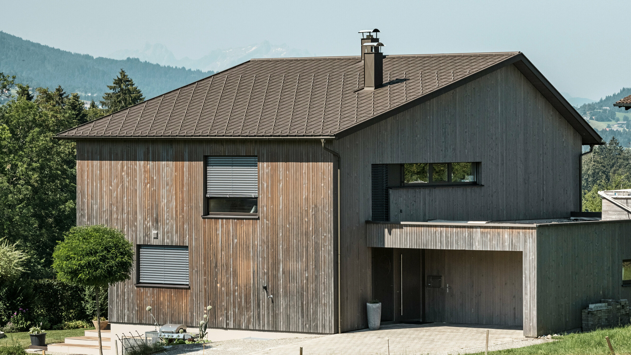 Dřevěná fasáda v kombinaci s hliníkovou střechou působí harmonicky