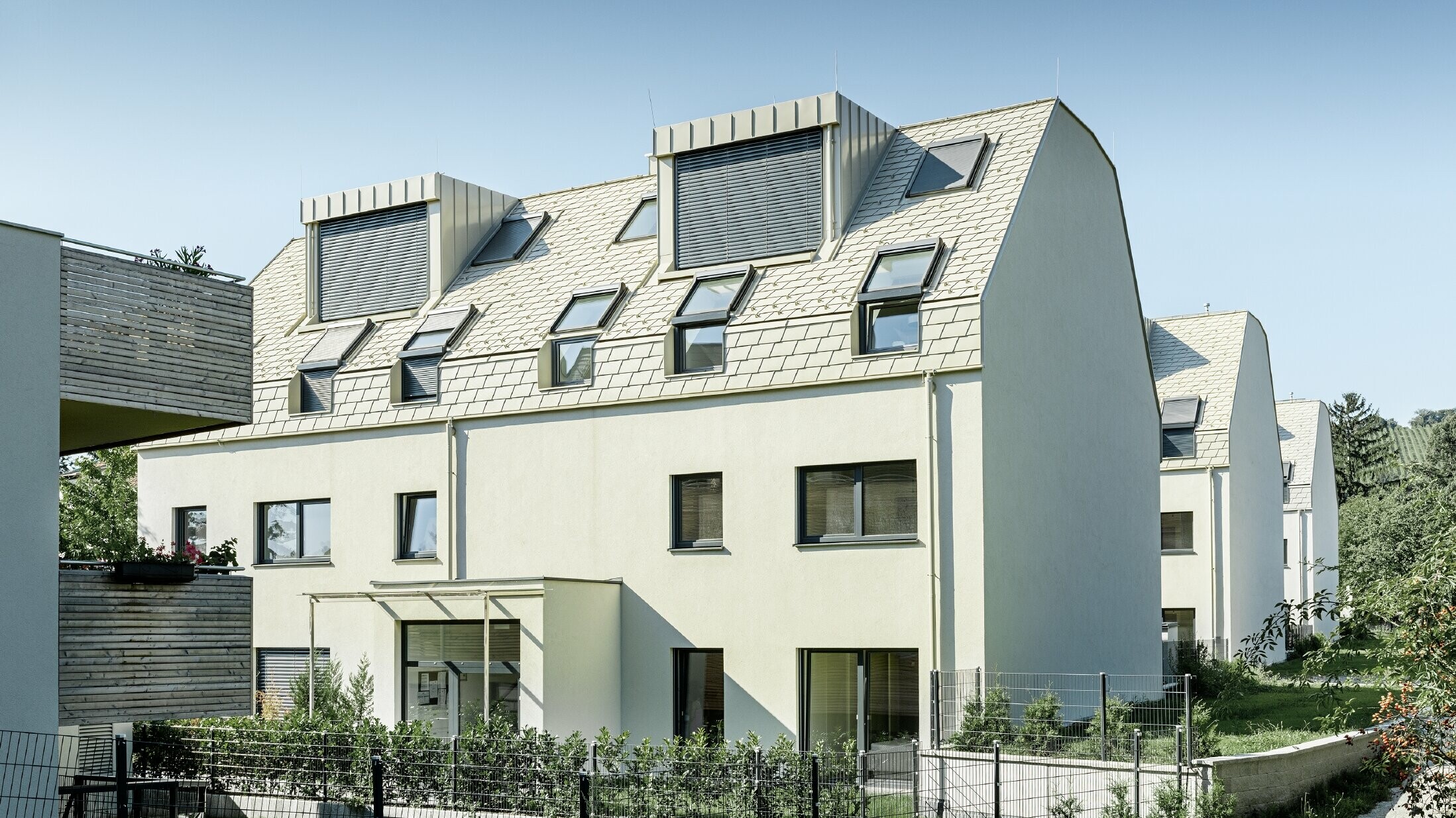 neue Wohnhausanlage mit großer Aluminium Dachfläche und vielen Dachflächenfenstern 