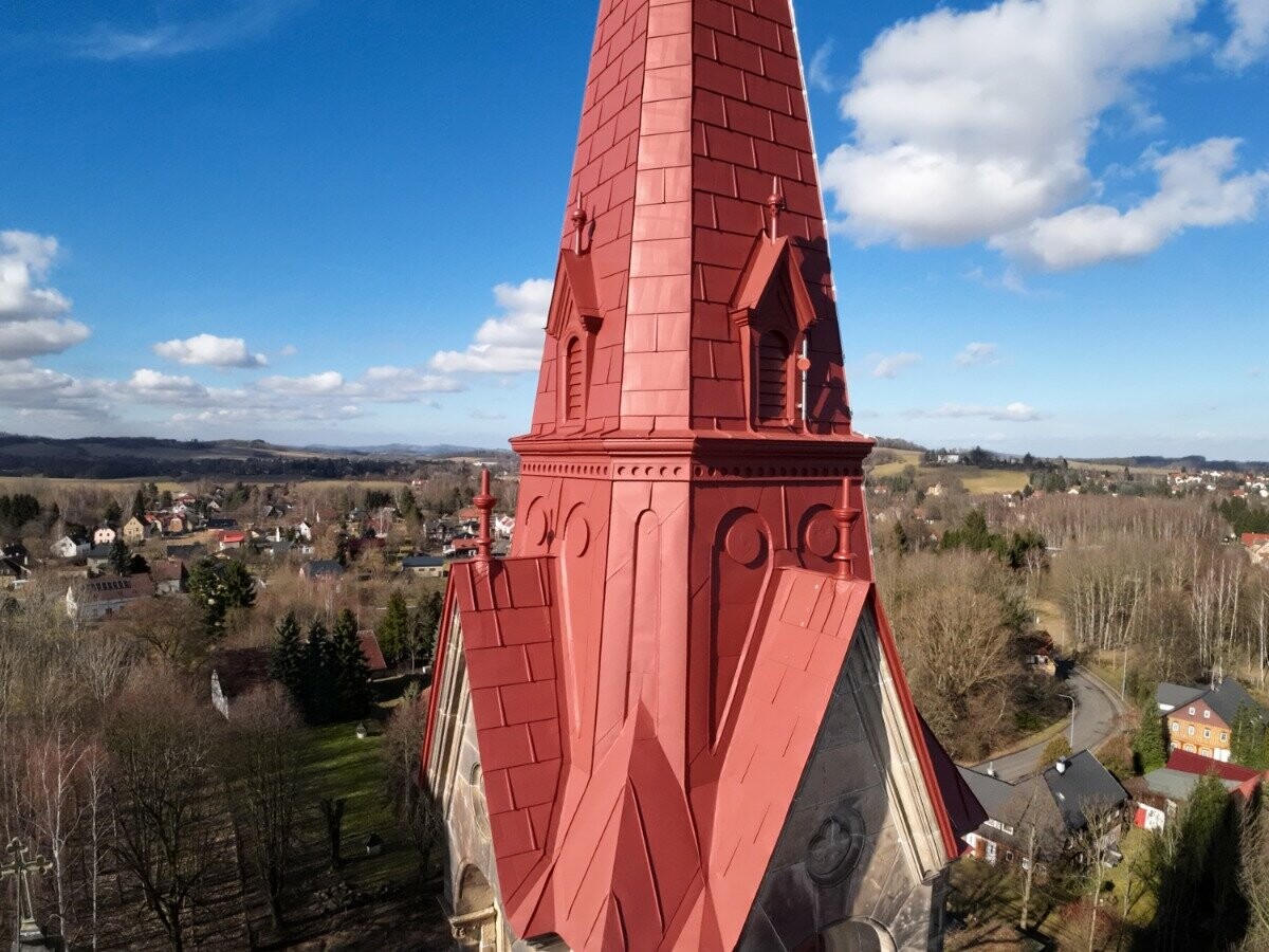 Věž po rekonstrukci, která byla opláštěna produkty PREFA: FX.12 a PREFALZ v barvě  P.10 tmavě červené